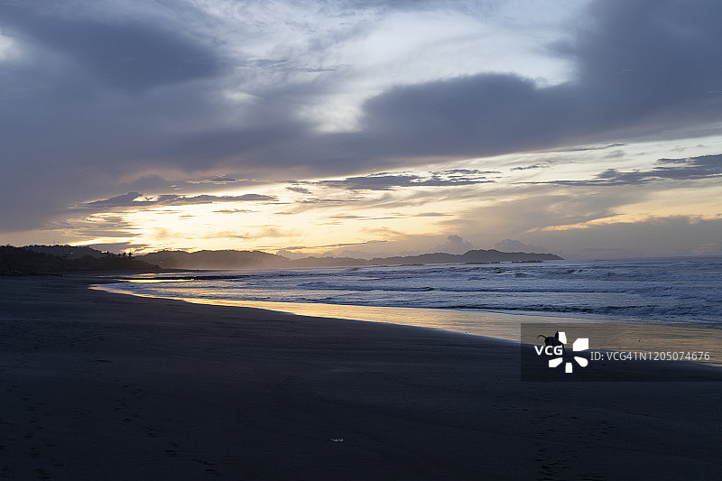 哥斯达黎加瓜纳卡斯特省奥斯蒂奥纳尔多云日出时的沙滩图片素材