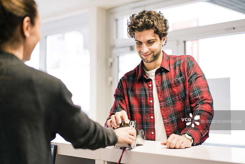 男人在商店柜台用信用卡支付图片素材