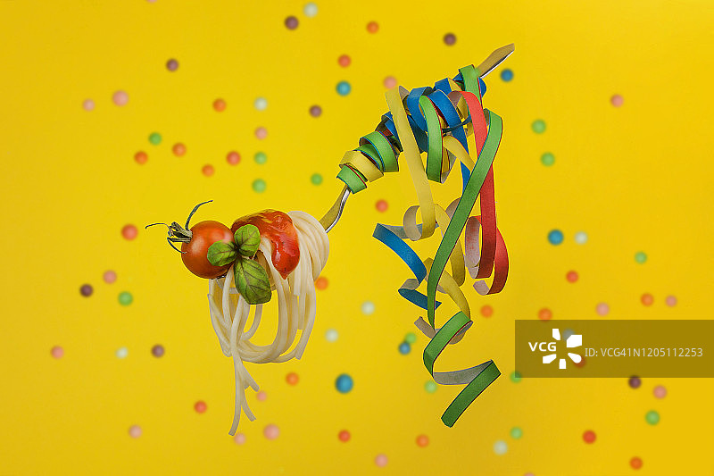 黄色背景与彩色散景中节日风格的意面叉子图片素材