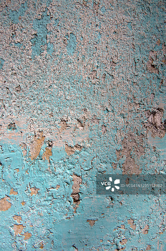 旧房屋灰泥外墙上剥落的青蓝色和白色油漆图片素材