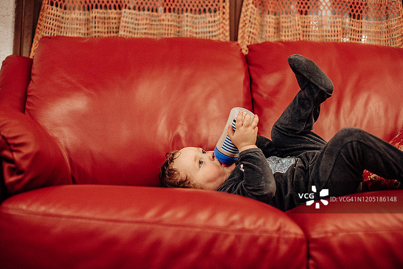 男婴自己用奶瓶喝奶图片素材