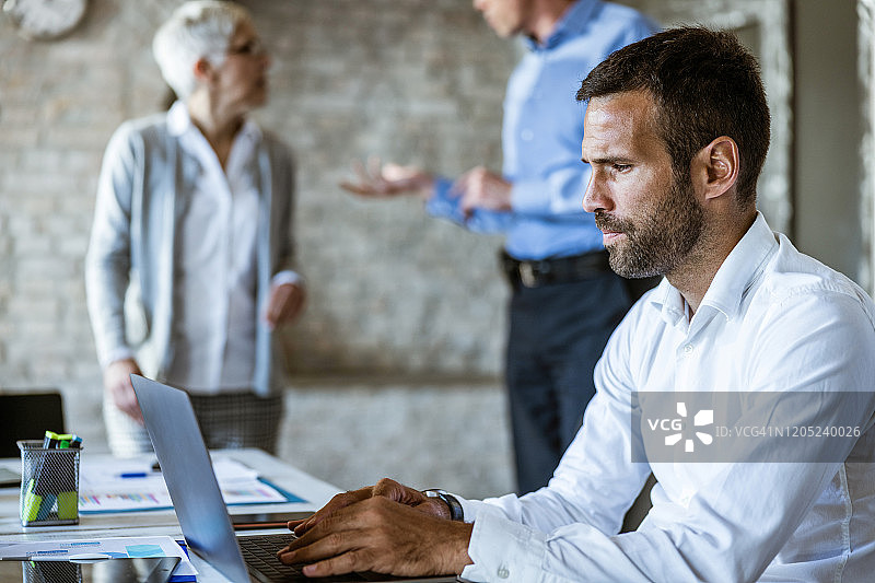 在办公室使用电脑的严肃商人图片素材