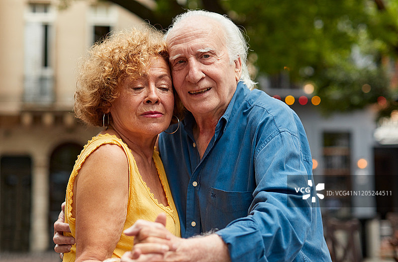 一对年长的夫妇在典型的布宜诺斯艾利斯广场跳探戈的特写图片素材