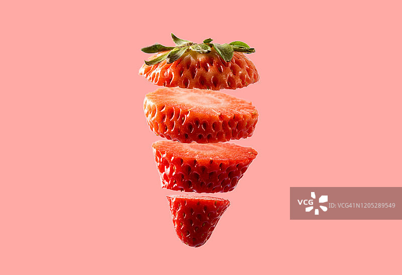 粉色背景上的草莓切片图片素材
