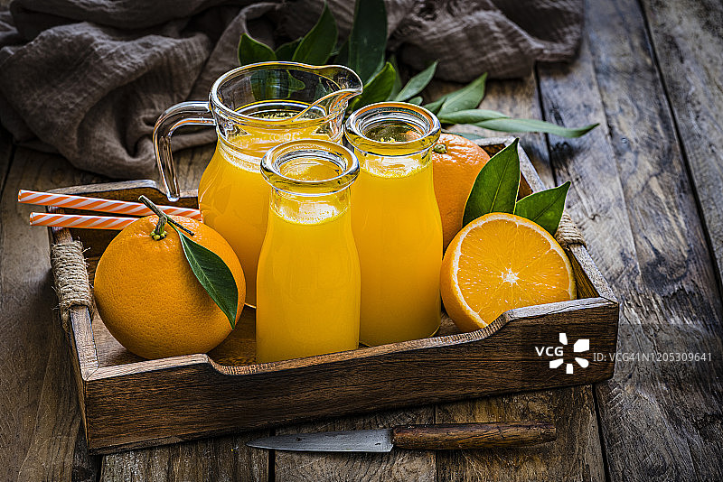 乡村木桌上的橙汁瓶图片素材