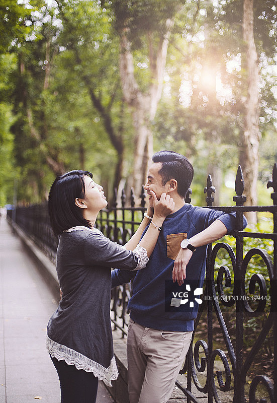 快乐的年轻亚洲情侣在台北公园里玩耍图片素材