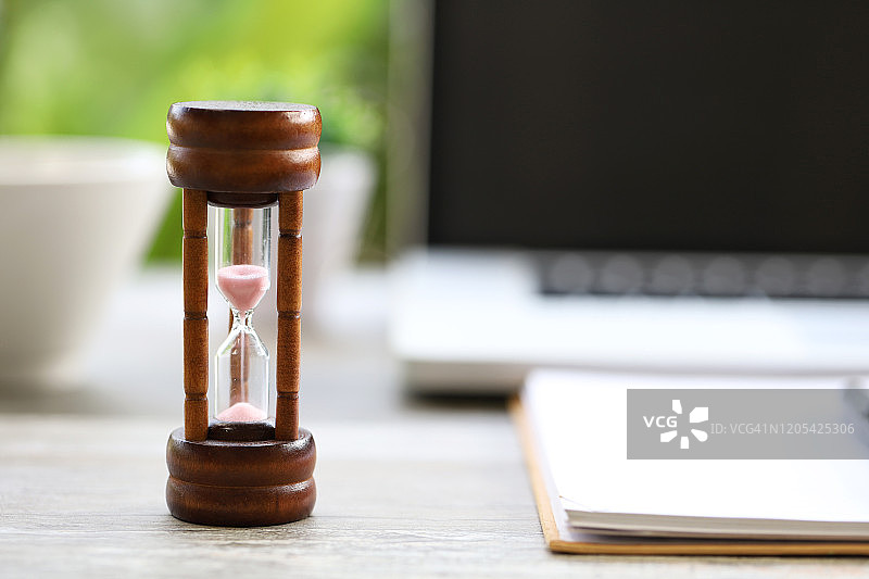 以书籍和笔记本为背景的沙漏：阅读桌，书桌图片素材