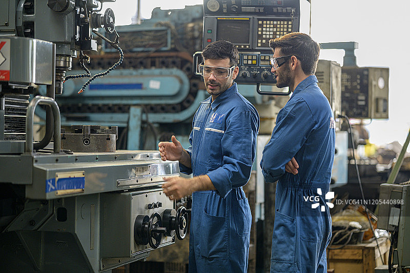 工程师主管向新员工讲解数控铣床使用图片素材