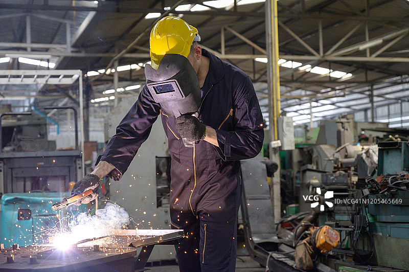 戴口罩的工人在工厂焊接铁支架图片素材