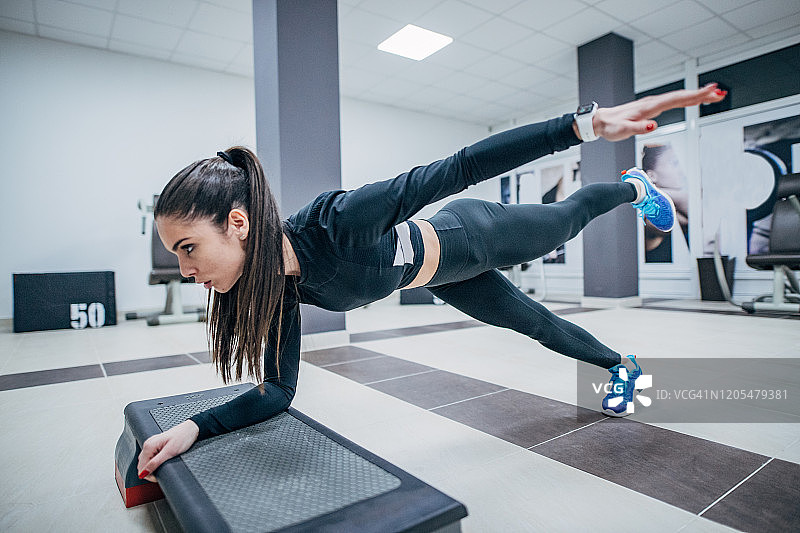 运动女人在有氧踏板设备上锻炼图片素材