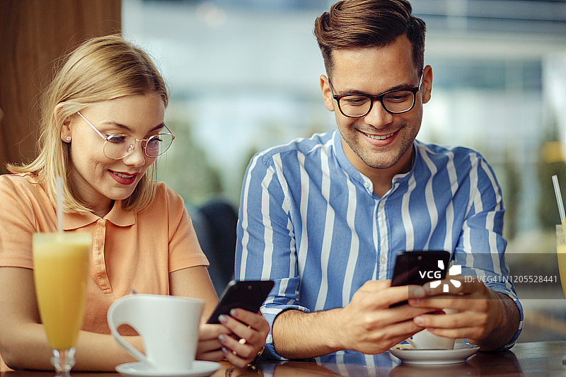 两位朋友在咖啡店玩耍图片素材