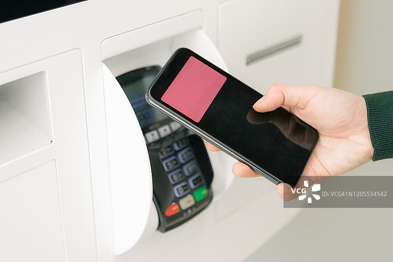 女人用智能手机支付购物费用的特写镜头图片素材