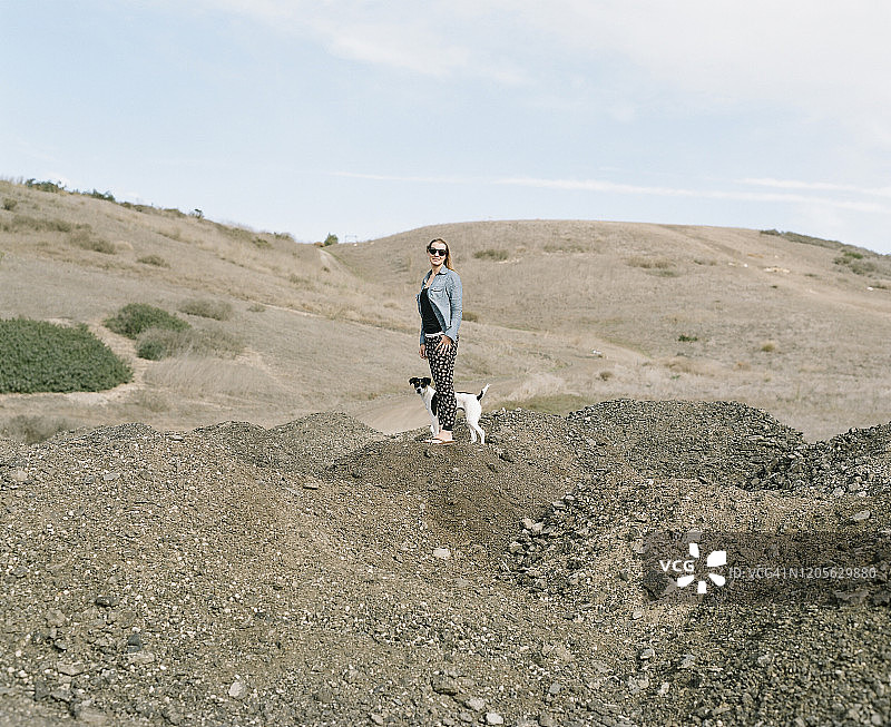 女人和狗站在徒步小道上图片素材