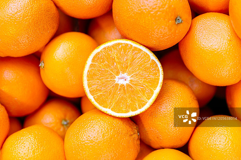 半个橙子，堆放在橙子堆上图片素材