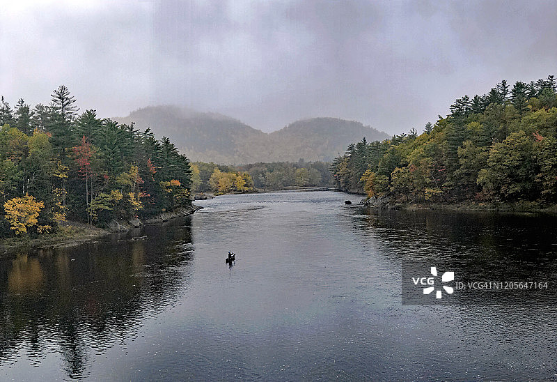 男人在吉利德的新罕布什尔州安德罗斯科金河上划独木舟，时值秋季图片素材