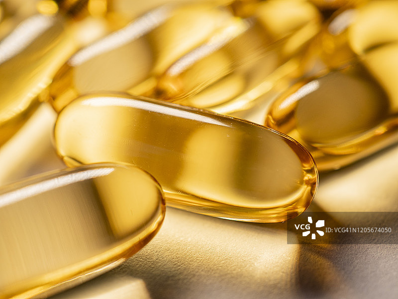 阳光下的金色鳕鱼肝油胶囊图片素材