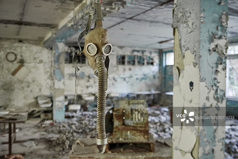 普里皮亚季废弃中学地板上的防毒面具和旧电视图片素材