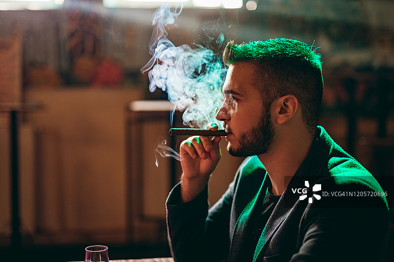 手持一杯威士忌的英俊男人图片素材