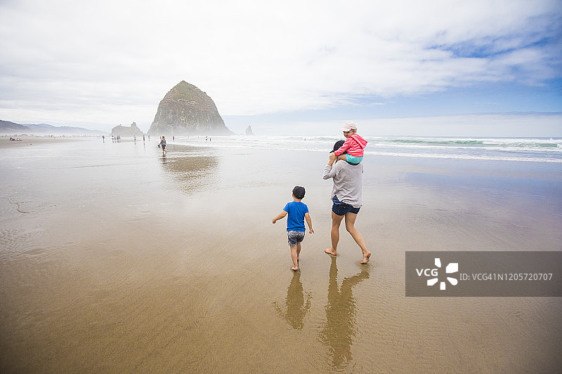 母亲和两个孩子走向干草堆岩，炮台海滩图片素材