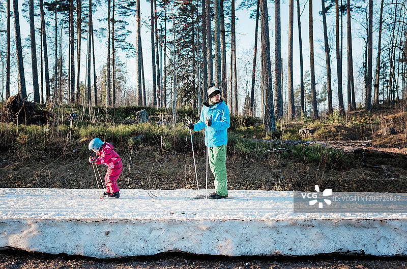 日落时分在瑞典与女儿一起越野滑雪的父亲图片素材