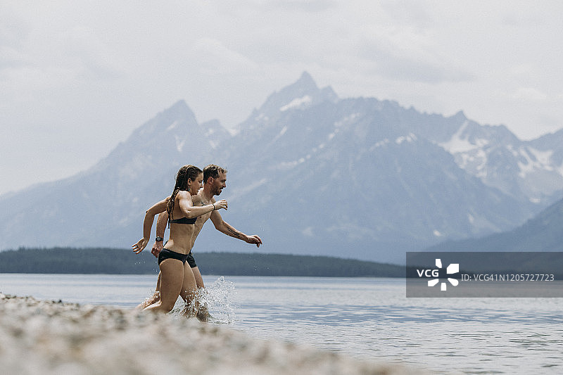 情侣在杰克逊湖游泳，背景是提顿峰图片素材