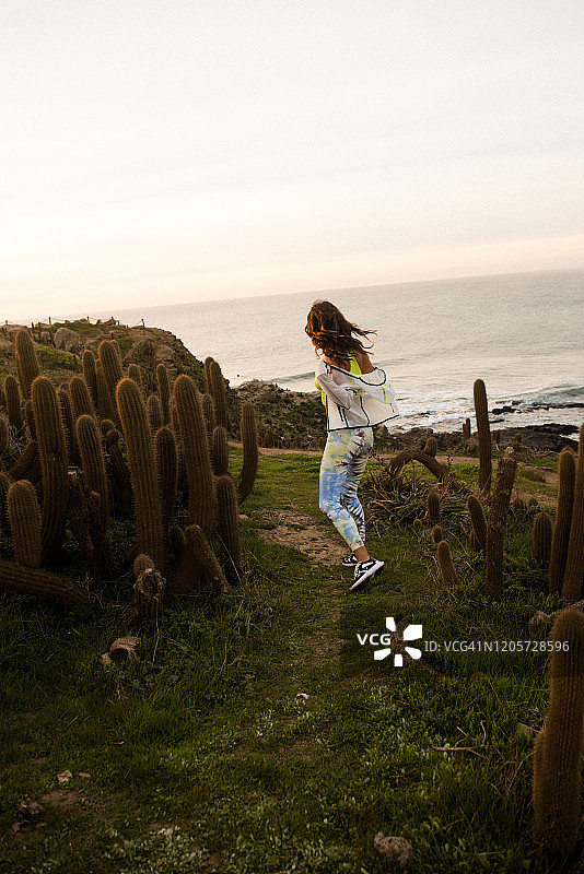 女徒步者在智利迷人的海岸上捕捉最后一缕阳光图片素材