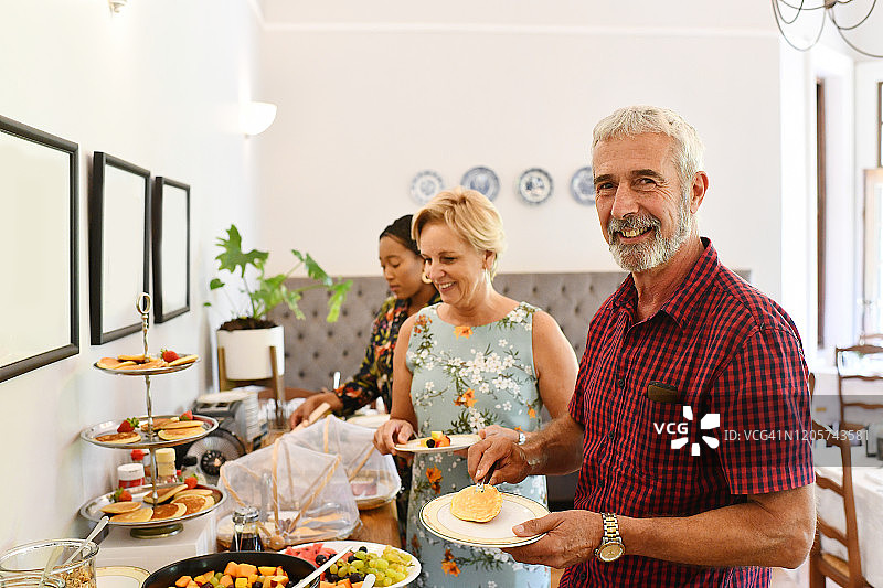 客人们在自助早餐时微笑面对镜头图片素材