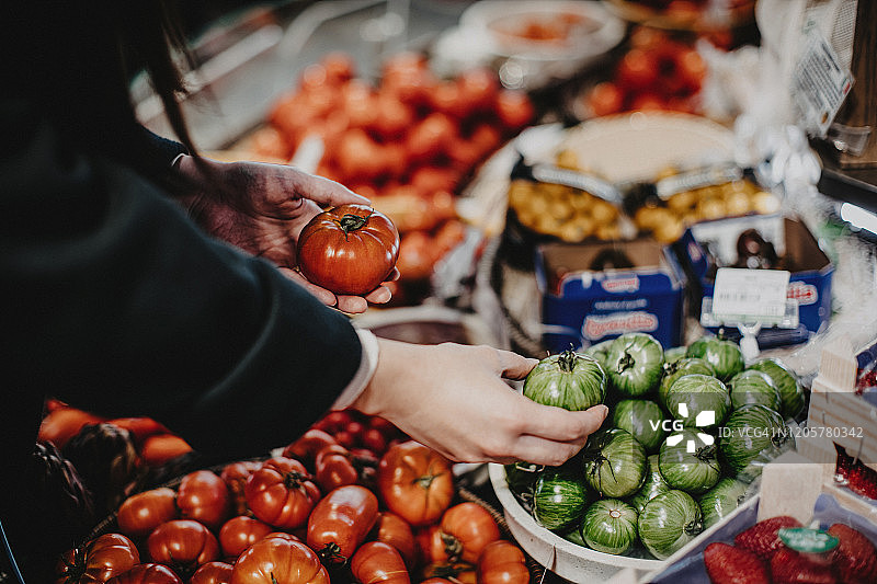 女人在超市购买新鲜果蔬，挑选红绿番茄图片素材