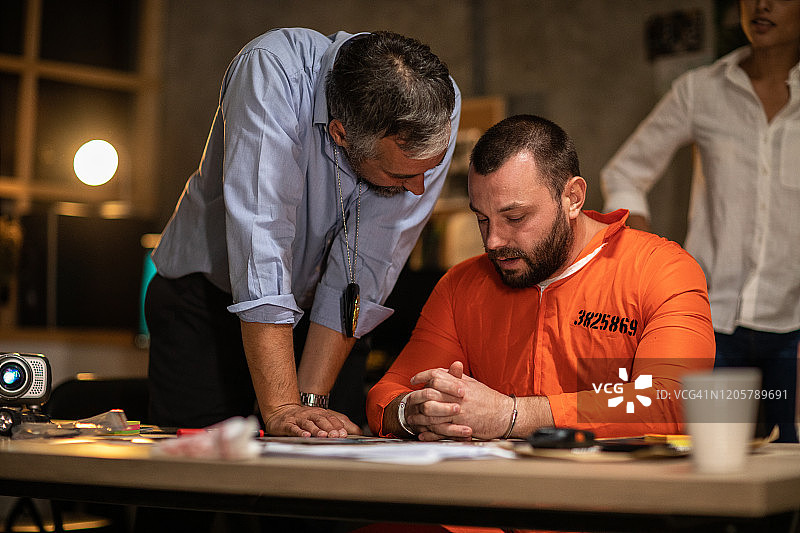 审讯室里戴着手铐接受审问的囚犯图片素材