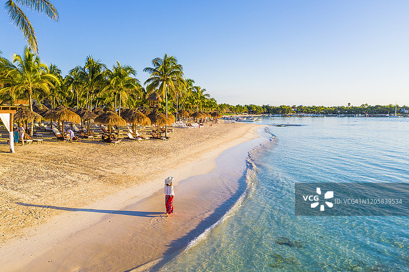 女子走在墨西哥阿库玛尔的加勒比海滩上图片素材