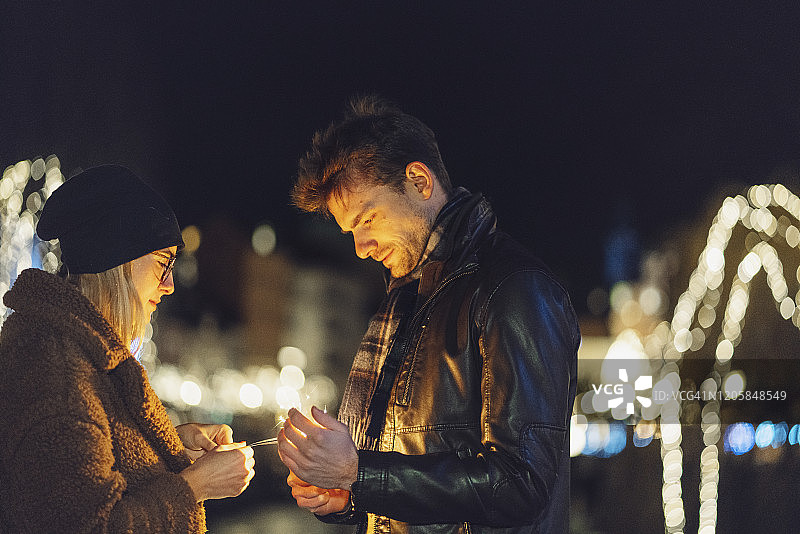 年轻情侣点燃烟花棒图片素材