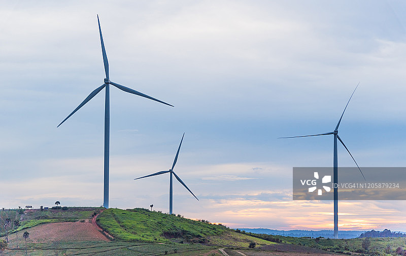 山间风力涡轮机、太阳能电池板和高压电线图片素材
