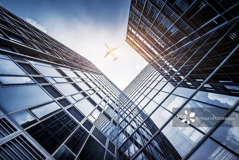 飞越城市商业建筑的飞机图片素材