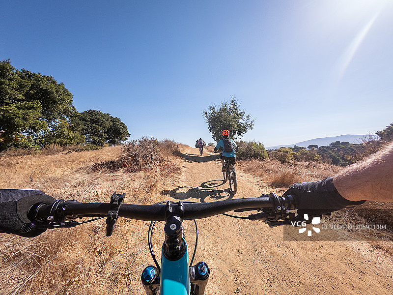 父亲与家人在越野小路上山地骑行的主观视角图片素材