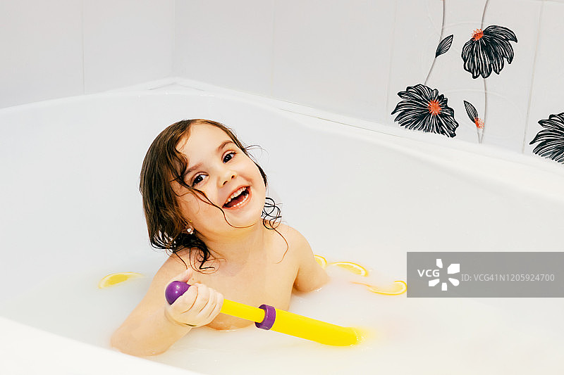 女婴用橘子洗牛奶浴。图片素材