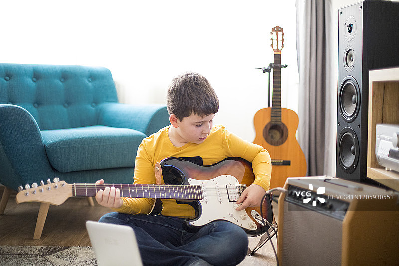 在家弹电子吉他的小男孩图片素材
