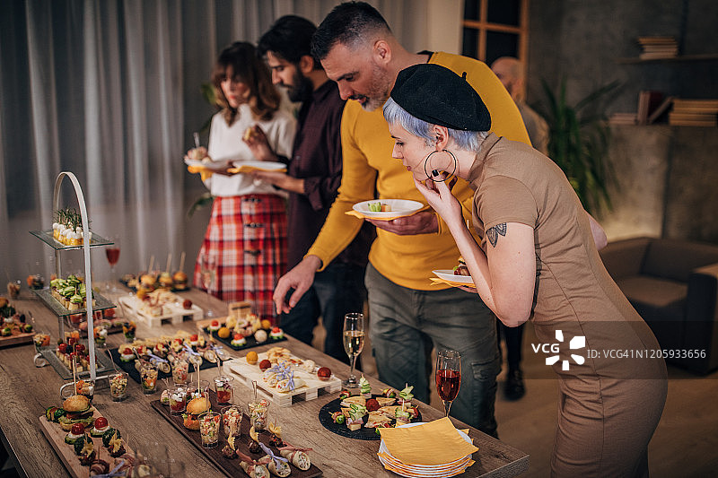 商务同事在公司派对上品尝美味佳肴图片素材