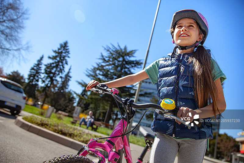 在街上骑自行车享受户外活动的小女孩图片素材