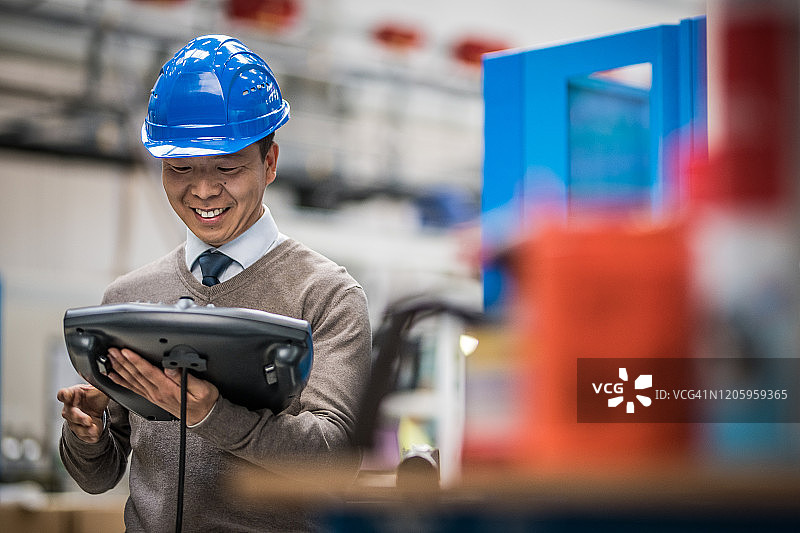 在工厂手持工业遥控器的男工程师图片素材