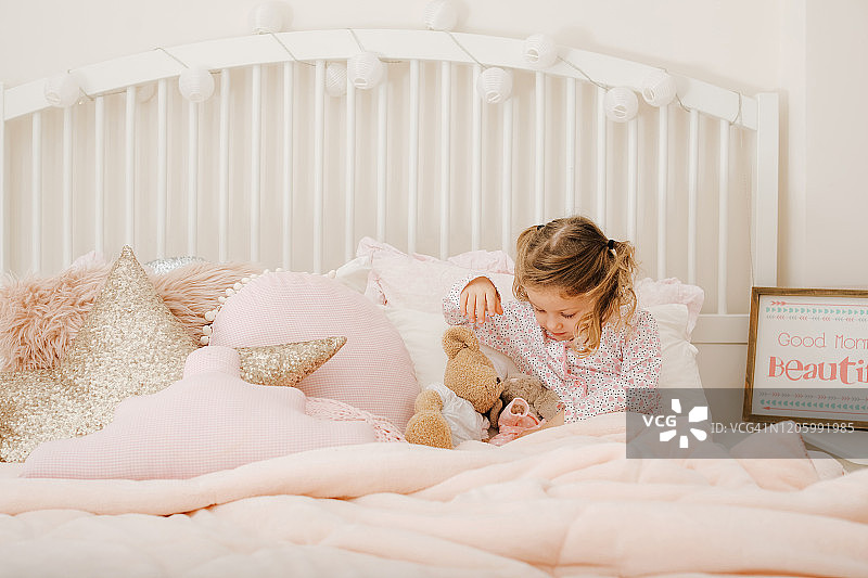 可爱的小女孩在床上睡觉图片素材