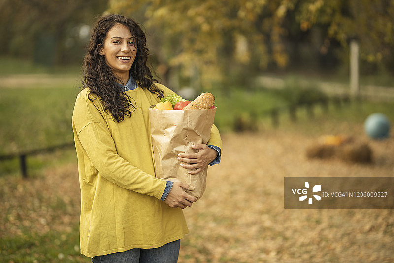 女人手提装满食品的纸袋图片素材