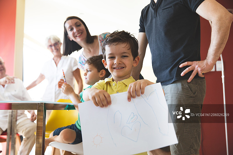 儿童展示在家与家人一起的绘画作品图片素材