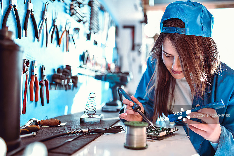 女工在车间工作台上焊接汽车零件图片素材