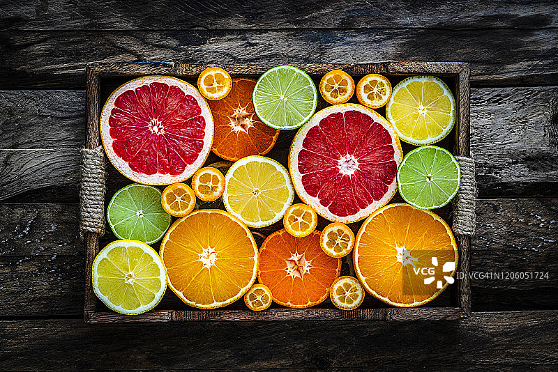 乡村木桌上箱装切片柑橘水果的俯视照片图片素材