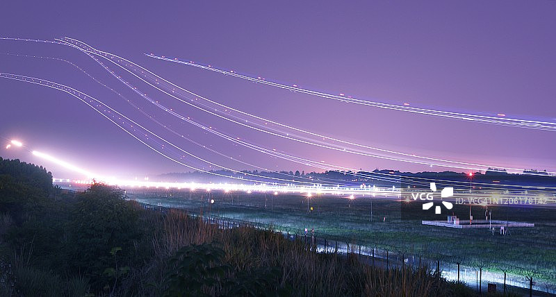 机场飞机的密集光轨夜景图片素材