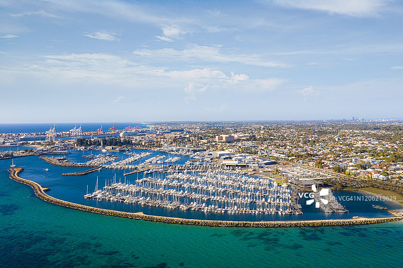 澳大利亚西澳大利亚州珀斯，弗里曼特尔港鸟瞰，港口停泊着帆船和游艇，背景是集装箱港口码头和城市图片素材