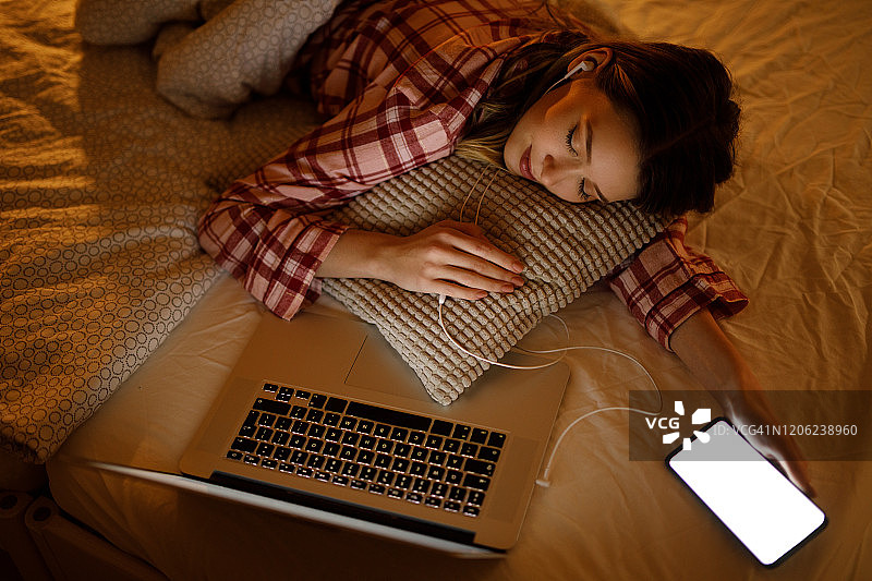 年轻女子在家在笔记本电脑前睡觉图片素材