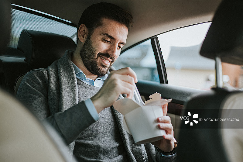 在车里匆忙吃意大利面的商人图片素材