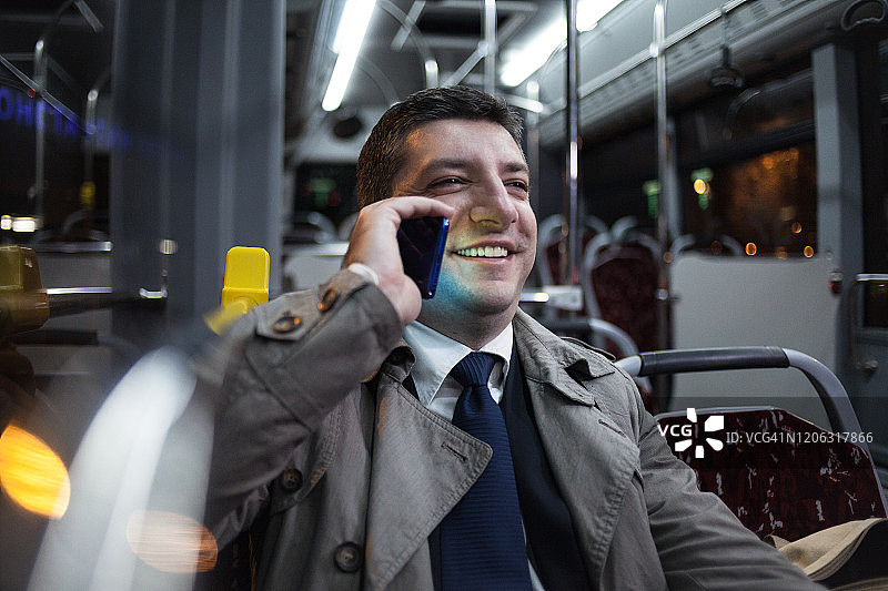 在公交车上打电话的商务人士图片素材