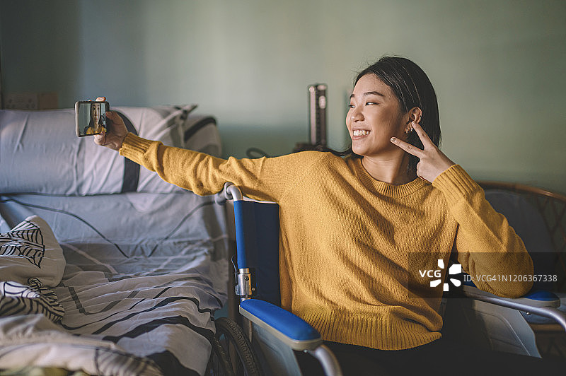 坐在轮椅上自拍的中国亚洲残疾女孩图片素材